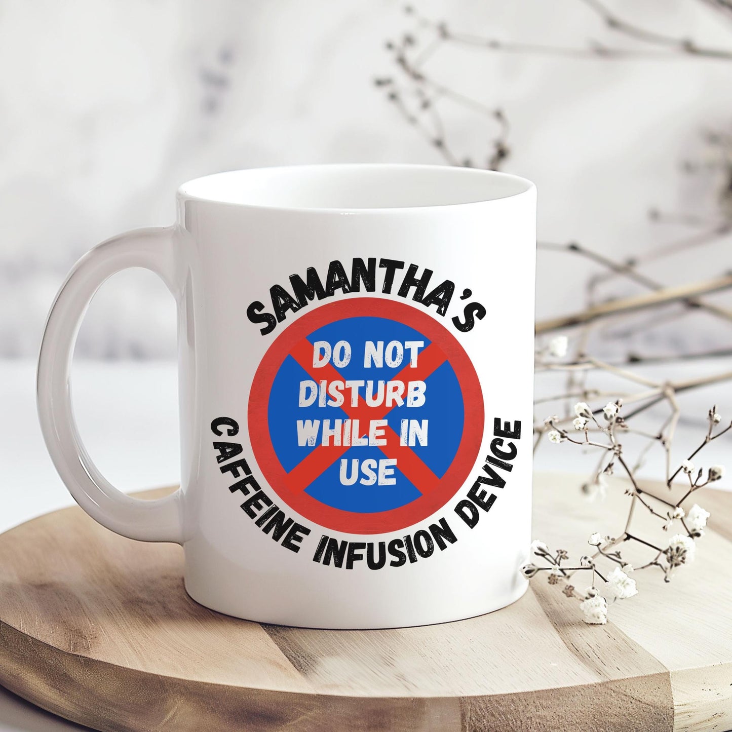 White ceramic coffee mug with coloured or Plain handle, on a wooden tray with black text that reads 'Samantha's Caffeine Infusion Device' surrounding a red and blue sign that says 'Do Not Disturb While in Use.' The perfect gift for a coffee lover
