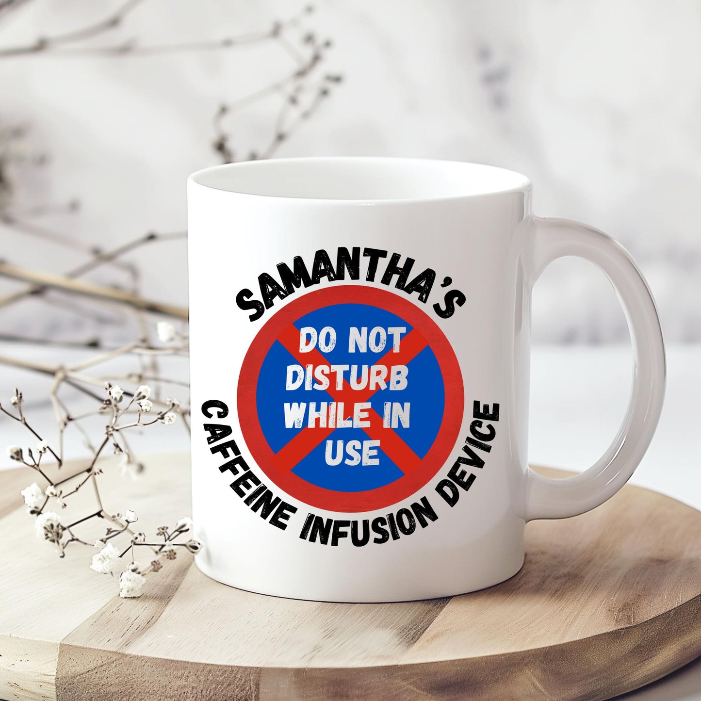 White ceramic coffee mug with coloured or Plain handle, on a wooden tray with black text that reads 'Samantha's Caffeine Infusion Device' surrounding a red and blue sign that says 'Do Not Disturb While in Use.' The perfect gift for a coffee lover