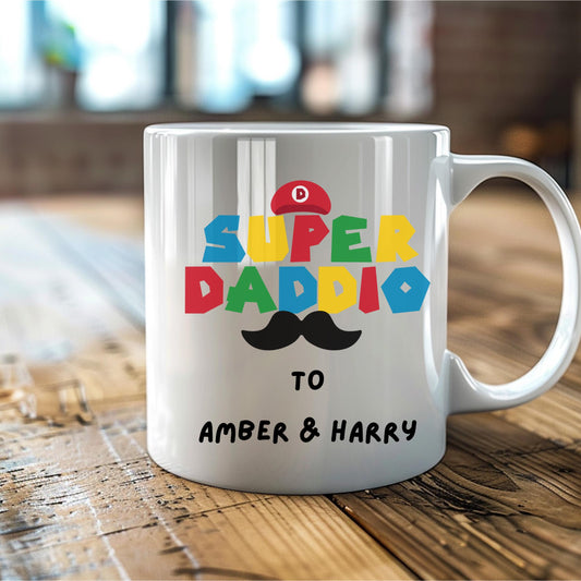 White ceramic coffee mug with colorful text reading &#39;Super Daddio&#39;, a red Mario-style hat, black moustache graphic, and personalised &#39;To Amber & Harry&#39; message – perfect custom Father&#39;s Day gift for gamer dads.