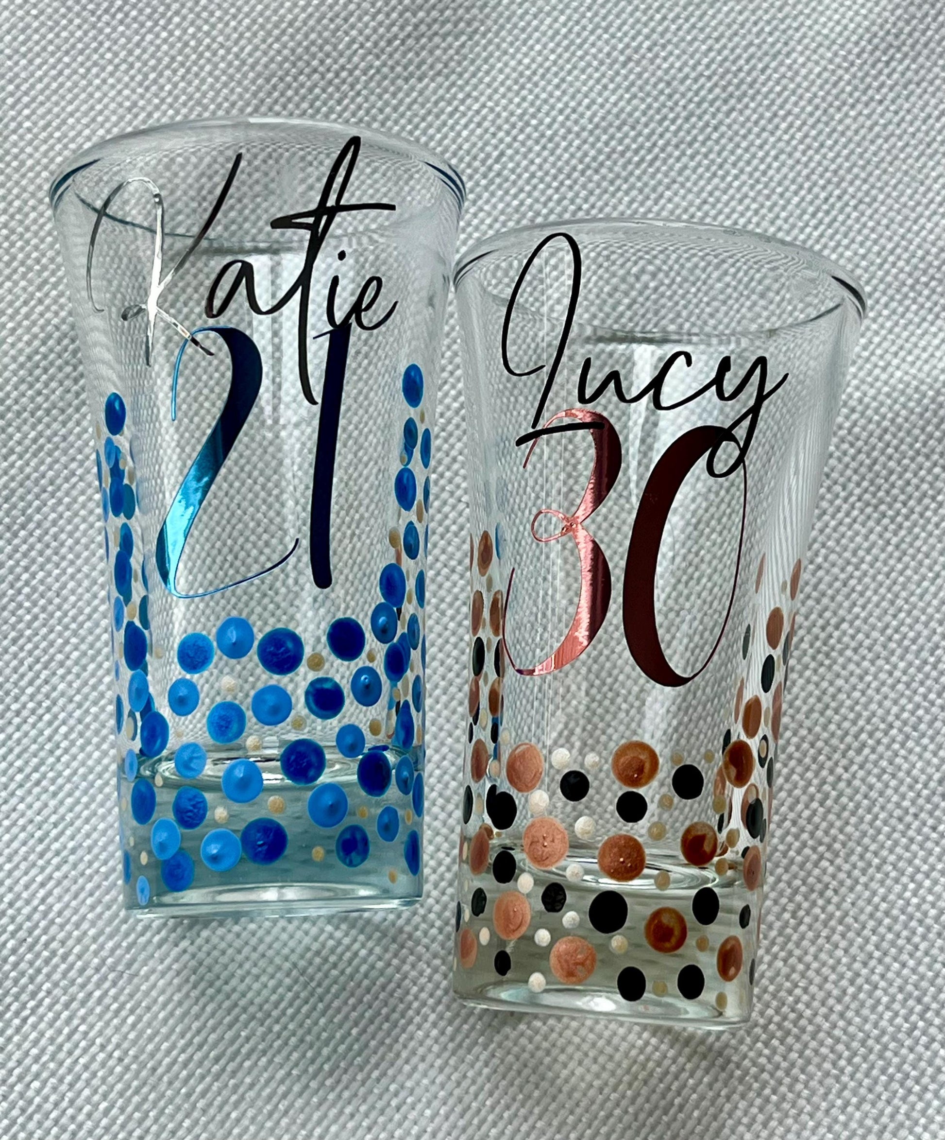 Personalised hand-painted birthday shot glasses with custom names and ages – 18th, 21st, 30th, and 50th designs in pink, blue, copper, and purple dot patterns – unique milestone party gift idea