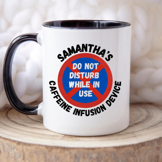 White ceramic coffee mug with coloured or Plain handle, on a wooden tray with black text that reads &#39;Samantha&#39;s Caffeine Infusion Device&#39; surrounding a red and blue sign that says &#39;Do Not Disturb While in Use.&#39; The perfect gift for a coffee lover
