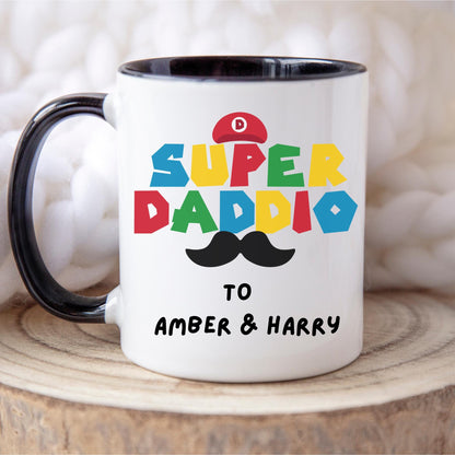 White ceramic coffee mug with colorful text reading &#39;Super Daddio&#39;, a red Mario-style hat, black moustache graphic, and personalised &#39;To Amber & Harry&#39; message – perfect custom Father&#39;s Day gift for gamer dads.